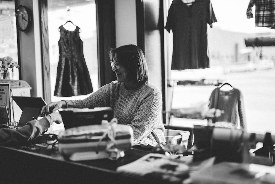 A woman happily assisting a customer at a thrift store counter in Minnesota, USA.